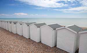 White beach huts on the English channel between Hastings and Eastbourne 